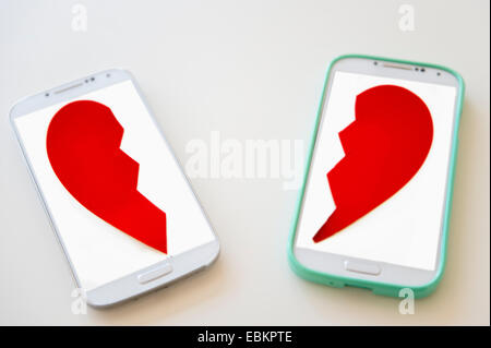 Studio shot of smart phones with broken heart on screen Stock Photo