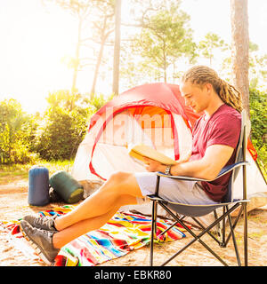 USA, Florida, Tequesta, Man reading book in front of tent Stock Photo