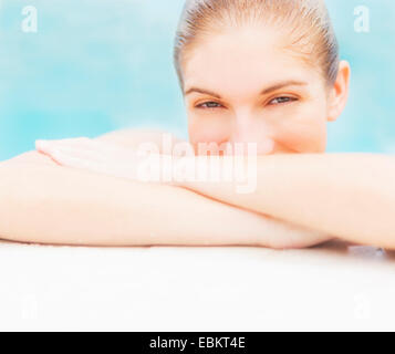 Portrait of woman on edge of swimming pool Stock Photo