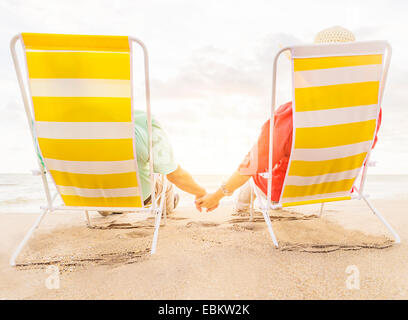 USA, Florida, Jupiter, Rear view of couple sitting in lounge chairs on beach Stock Photo