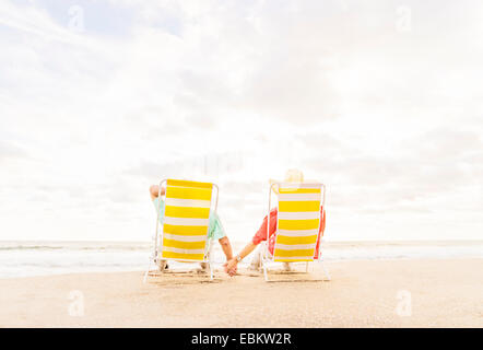 USA, Florida, Jupiter, Rear view of couple sitting in lounge chairs on beach Stock Photo