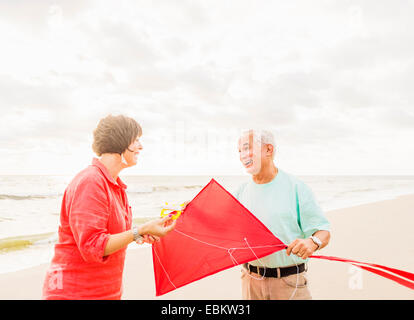 USA, Florida, Jupiter, Couple flying kite together on beach Stock Photo