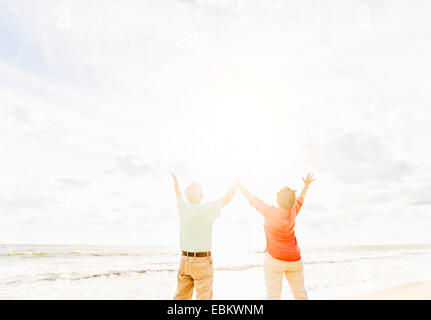 USA, Florida, Jupiter, Rear view of couple with arms raised on beach Stock Photo