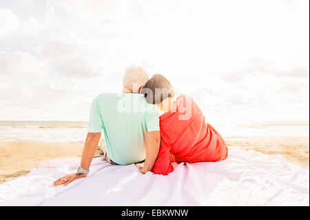 USA, Florida, Jupiter, Rear view of couple sitting on beach at sunrise Stock Photo