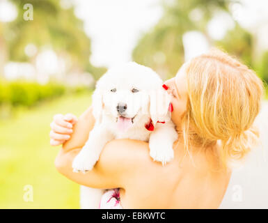 USA, Florida, Jupiter, Close-up shot of young woman embracing white puppy Stock Photo