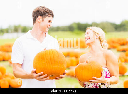 USA, Florida, Jupiter, Portrait of young couple holding pumpkins Stock Photo