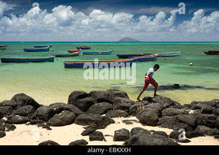 Mauritius, Grand Gaube public beach, boy on rocks Stock Photo
