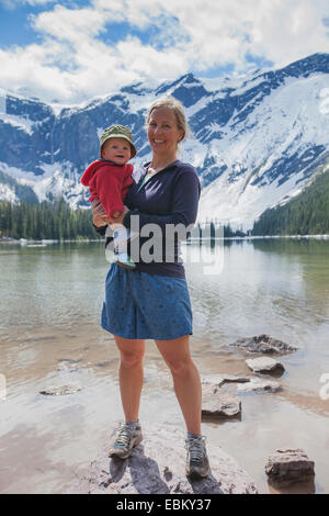 USA, Montana, Glacier National Park, Avalanche Lake, Woman with son (4-5) standing on lakeshore Stock Photo