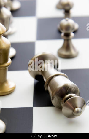 Classic chess game - fallen silver king on chessboard Stock Photo