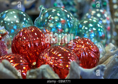 Red Christmas balls in front of clear crystal Christmas decorations in a wood basket. Stock Photo