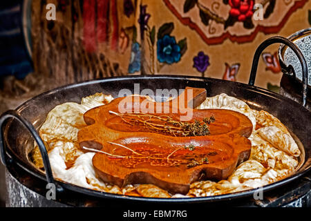 Cabbage rolls cooked in a large pot, with a wooden spice placed over, and a rustic background with traditional embroidery materi Stock Photo