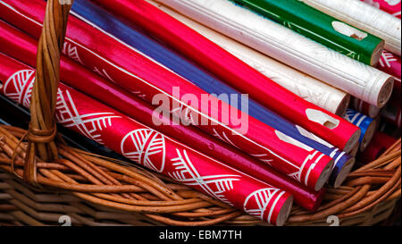 Whistles made from different types of wood and colored, placed on a wicker basket. Stock Photo