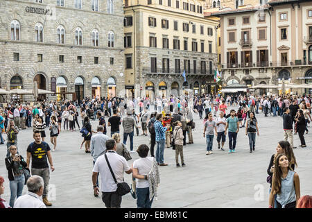 view looking northwest across historic Piazza della Signoria crowded with pedestrians Florence Italy