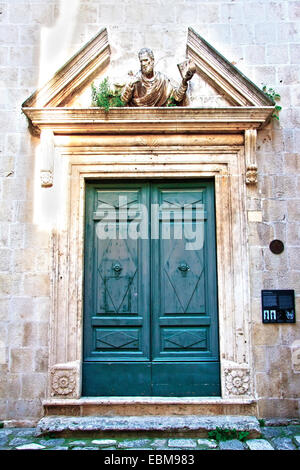 Green wooden St. Peters church doors in town of Trogir, Dalmatia, Croatia Stock Photo