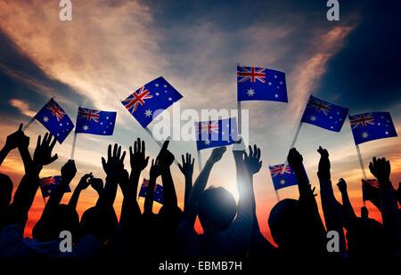 Group of People Waving Australian Flags in Back Lit