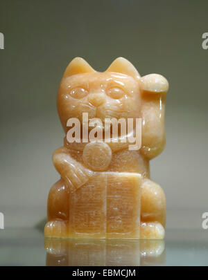 Maneki-neko (lucky waving fortune cat) jade sculpture Stock Photo