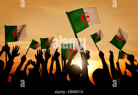 Silhouettes of People Holding Flag of Algeria Stock Photo