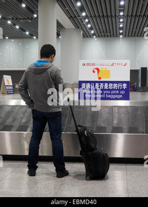 Person waiting for luggage at the baggage claim carousel at the Xian Xianyang international Aiport in China, Asia Stock Photo