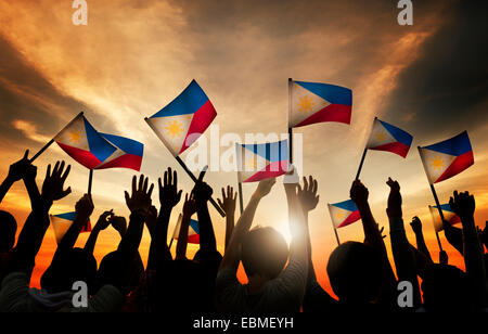 Group of People Waving Filipino Flags in Back Lit Stock Photo