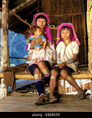Long-necked woman with a girl and a baby of the Padaung mountain tribe, also known as giraffe women, wearing neck rings