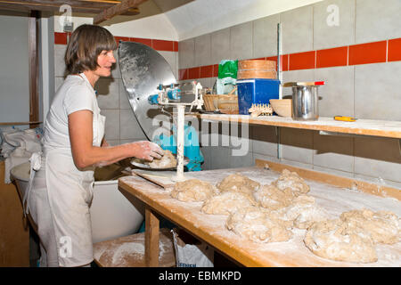 Farmer making bread in her own own bakery on the farm, weighing dough, Tyrol, Austria Stock Photo