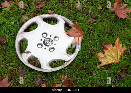 A lost hubcap lying on a roadside verge. Stock Photo