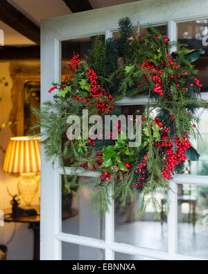 Christmas wreath of pine, holly and ivy on front door Stock Photo