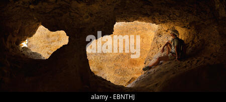 hiker under an arch in Sesriem canyon, Namibia, Namib Naukluft National Park Stock Photo