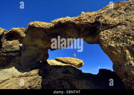 hiker on at a rock arch in the desert of national park of Naukluft, Namibia, Namib Naukluft National Park Stock Photo