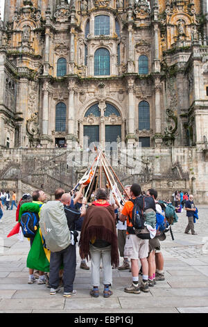 Way of St. James, brasilian pilgrims drawing their walkingssticks together in front of the cathedral, Spain, Galicia, A Coruna, Santiago De Compostela Stock Photo