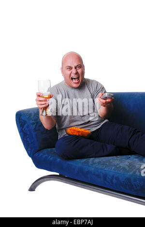 man with beer, chips and remote control sitting on sofa Stock Photo