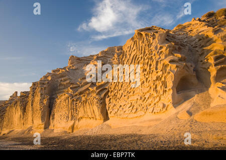 Vlyhada, Santorini, South Aegean, Greece. Eye-catching tufa cliffs towering above the beach, sunset. Stock Photo