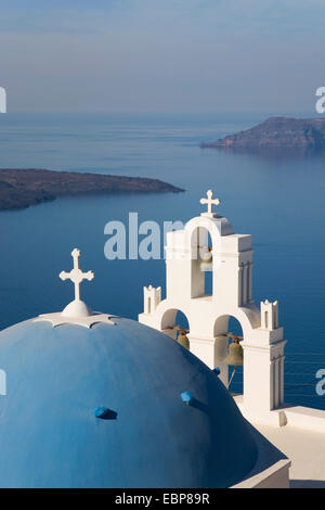 Firostefani, Santorini, South Aegean, Greece. View over the caldera, dome and bell-tower of typical church in foreground. Stock Photo