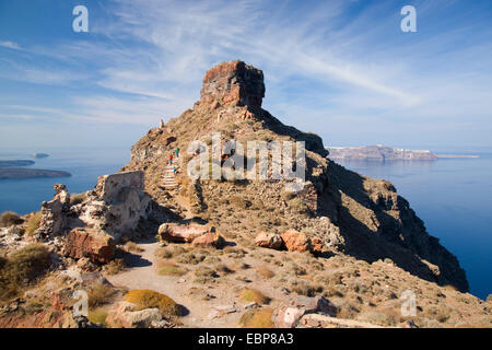 Imerovigli, Santorini, South Aegean, Greece. Skaros Rock towering above the caldera, visitors on steps to the summit. Stock Photo