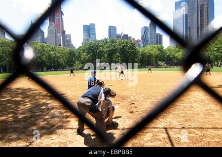 View of a baseball game in New York's Central Park through a chainmail fence Stock Photo