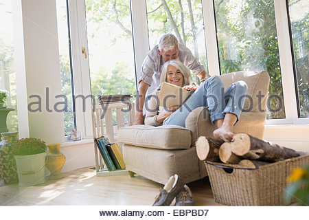 Senior couple reading book in armchair