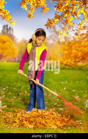 smiling girl in orange jacket posing with credit cards isolated on pink