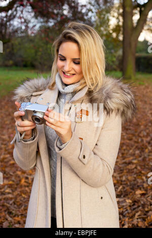 young woman looking through photos on her camera Stock Photo