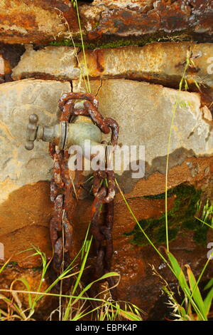 An old tap and chain beneath a rusty water tank in rural Australia. Stock Photo