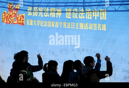 Hefei, China's Anhui Province. 4th Dec, 2014. College students sign names during an activity marking China's first national Constitution Day at Anhui University in Hefei, capital of east China's Anhui Province, Dec. 4, 2014. © Liu Junxi/Xinhua/Alamy Live News Stock Photo