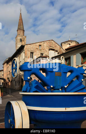Old dough kneading machine (ca. 1930) from the pasta factory Tomadini in front of the old town of Pordenone with campanile.Italy Stock Photo