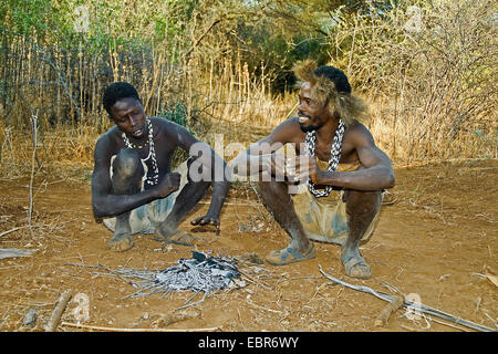 two Hadzabe bushmen at the fireplace, Tanzania, Lake Eyasi, Serengeti Stock Photo