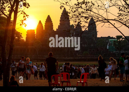 Tourists watch the spectacular sight of the sun rising over Angkor Wat. Stock Photo