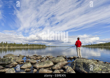 man fishing at Rogen lakeshore, Sweden, Haerjedalen, Naturreservat Rogen Stock Photo