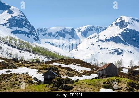 wooden huts in front of snow covered mountains, Sogn og Fjordane Fylke, Norway, Lapland Stock Photo