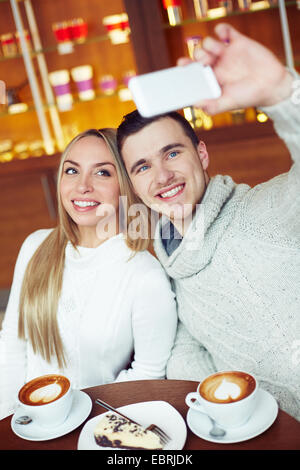 Joyful dates taking their selfie while sitting in cafe Stock Photo