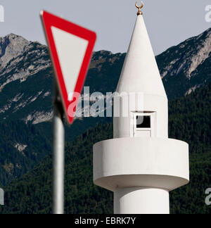 minaret and give way sign in front of looming mountains, Austria, Tyrol, Telfs Stock Photo