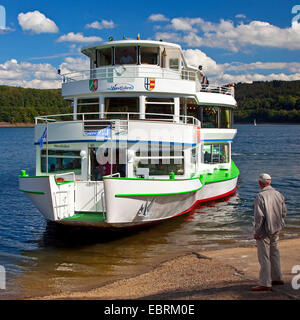 man stands at the landing stage Sondern at Lake Bigge in front of approaching passenger ship, Germany, North Rhine-Westphalia, Sauerland Stock Photo