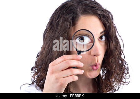 dark-haired woman looking through loupe Stock Photo