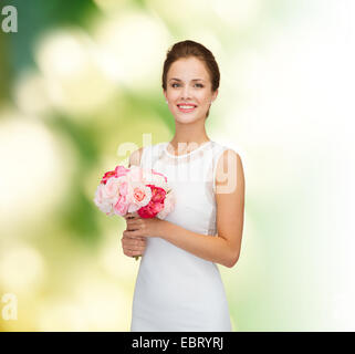 smiling woman in white dress with bouquet of roses Stock Photo